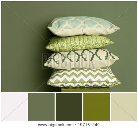 Stack of pillows and palette of colors combination on olive background