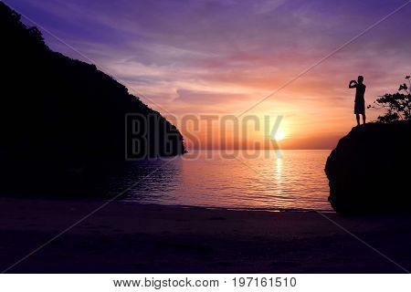 Rock climbing with sunset on the beach in Thailand.