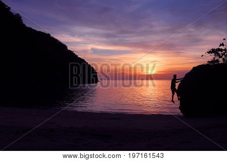 Rock climbing with sunset on the beach in Thailand.