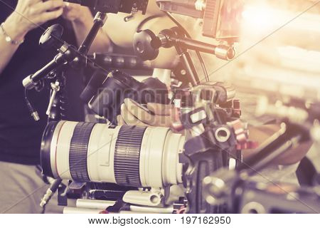 Cameraman with his video camera shooting, Hands Adjusting Camera,film production crew, behind the scenes background.