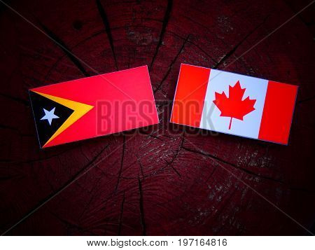 East Timorese Flag With Canadian Flag On A Tree Stump Isolated