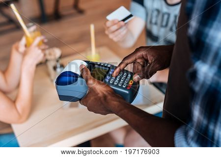 Cropped View Of African American Waiter With Terminal Taking Payment With Credit Card In Cafe