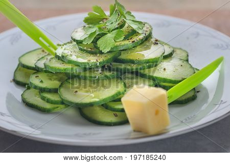 Fresh cucumber salad on a flat porcelain plate