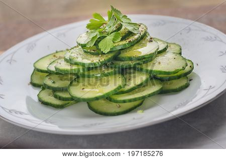 Fresh cucumber salad on a flat porcelain plate