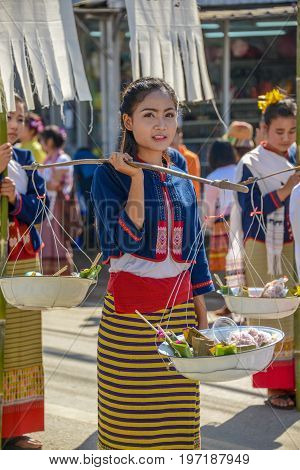 CHIANGMAI THAILAND - JANUARY 25 2015: Indigenous girl holding counterpoise enameled basin of food in parade of 22nd Traditional Skirt Fabric and The Indigenous Product and Culture Festival in Mae Chaem Chiangmai Thailand