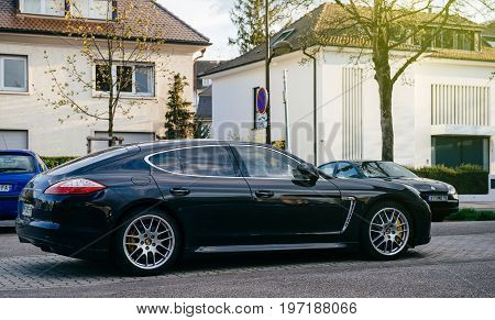 PARIS FRANCE - APR 8 2016: Black Panamera Prosche parked on the streets of France with luxury houses in the background