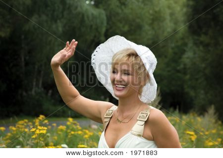 Femme blonde dans un chapeau blanc