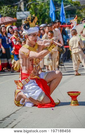 CHIANGMAI THAILAND - JANUARY 25 2015: Indigenous dancer man with traditional costume holding tray with pedestal of flower dancing in parade of 22nd Traditional Skirt Fabric and The Indigenous Product and Culture Festival in Mae Chaem Chiangmai Thailand