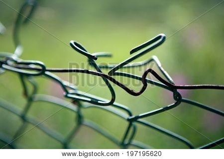 broken mesh fence as a symbol of defencelessness close up