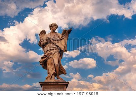 Marble statue of Angel with the Sudarium at sunset, one of the ten angels on Saint Angel Bridge, symbols of Christ's Passion, Rome, Italy