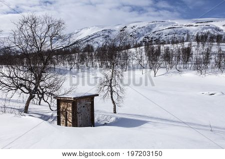 Wooden, secret place, heart on the door and deep, deep snow. Indisposed for the moment. Mountain in the background.