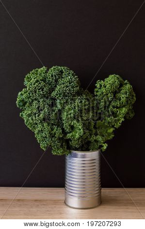 Vertical background with raw kale in a metal jar. Fresh kale leaves