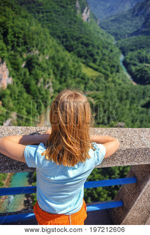 rear view of lonely girl looking on canyon on Djurdjevica Tara Bridge, Montenegro. Durmitor reserve.