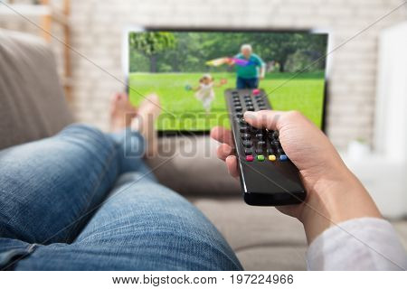 Close-up Of A Woman Changing The Channel With Remote Control While Watching Television