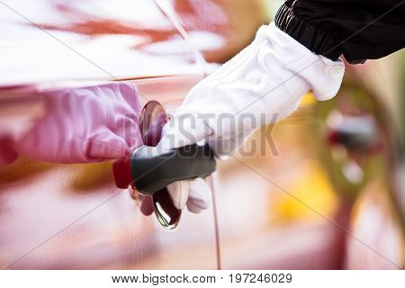 Close-up Of A Valet's Hand Opening Red Car Doors