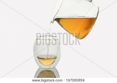 Tea pouring into Double-wall Glass Tea Cup, isolated in white