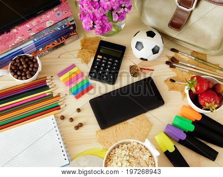 Smartphone with an empty screen and calculator surrounded by school supplies