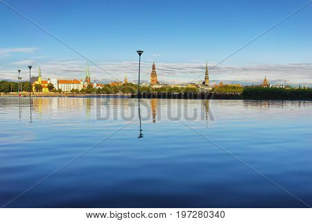The capital of Latvia is the ancient city of Riga on the Daugava river with reflection in the water on a summer sunny day