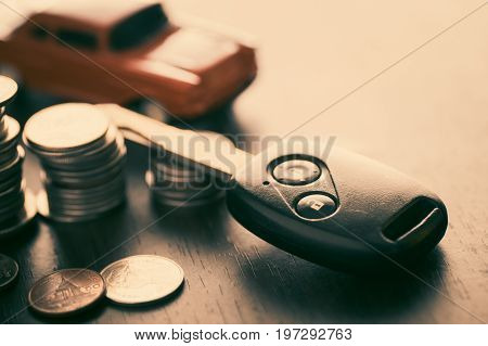 key of car and staced of money coins on wood table