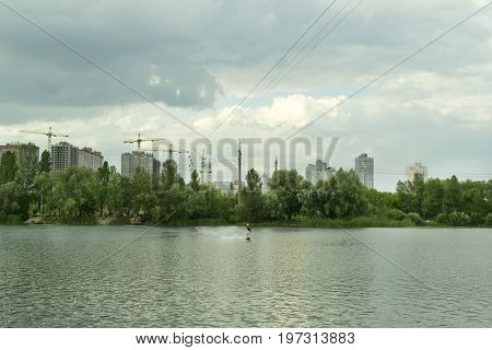 Men is engaged in wakeboarding on the background of construction