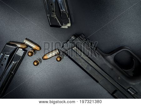 9 mm Pistol, bullets and magazine on drak background. Gun isolated