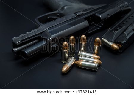 9 mm Pistol, bullets and magazine on drak background. Gun isolated