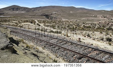 A railway track leading through the dry landscape near Sumbay, southern Peru
