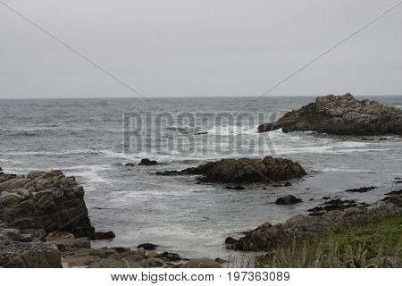 This is an image of off shore rocks at the Asilomar Reserve
in Pacific Grove taken on a over cast day.