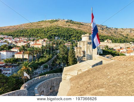 Old City Walls With Flag And Fort Minceta Dubrovnik