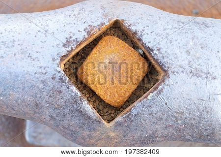 Rusting bolt set in horn cleat on dock