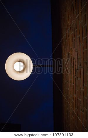 Contrast darness brightness orange bricks wall exterior street lantern