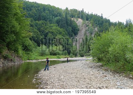 Two boys near mountain river in Carpathians Ukraine