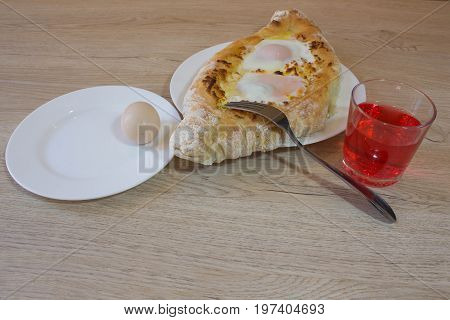 Adjarian Khachapuri - georgian cheese pie with egg. Adjarian khachapuri on a on a plate. Open pie with cheese in the shape of the boat