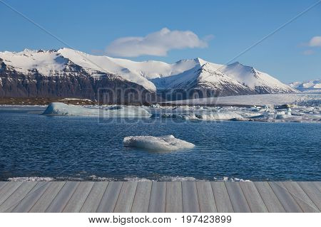 Opening wooden florr Ice on lagoon with snow covered mountain background Iceland winter season landscape background