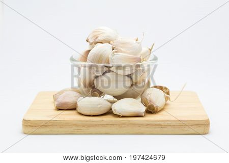 Glass cup rood garlic on wooden board on white background