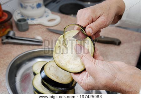 Senior women pealing eggplant with sharp knife