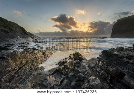 Beautiful Colorful Vibrant Sunset Over Rocky Beach With Long Exposure