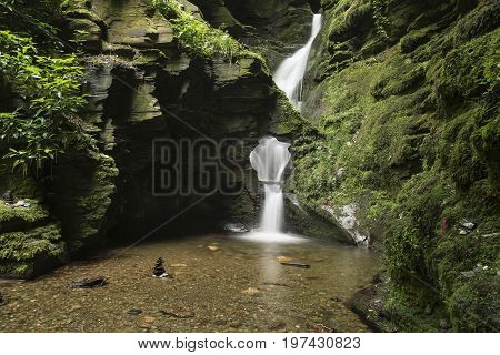 Beautiful Flowing Waterfall With Magical Fairytale Feel In Lush Green Forest Location