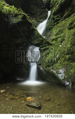 Beautiful Flowing Waterfall With Magical Fairytale Feel In Lush Green Forest Location