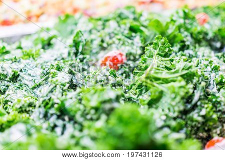 Green Kale Leaves And Tomatoes In Ceaser Salad Bar With Tongs