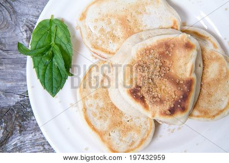 Pancakes With Apples Decorated With Mint And Brown Sugar