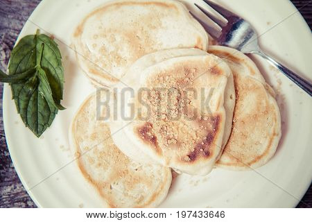 Pancakes with apples decorated with mint and brown sugar