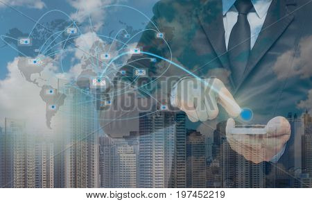 Double exposure of businessman using the smart phone with sending the email via network line on cityscape background business concept