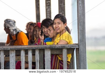 MANDALAY MYANMAR - MARCH 13 : Unidentified Burmese women smiling at the ubein bridge on March 13 2016 in Mandalay Myanmar. The U-Bein bridge is the longest teak bridge in the world 1.2km length.