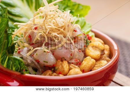 Fresh salad with lupini beans and raw fish served with lettuce leaf in bowl on table napkin