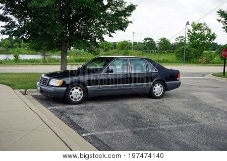 PLAINFIELD, ILLINOIS / UNITED STATES - JUNE 30, 2017: A 1996 black Mercedes-Benz S420 luxury sedan is parked in the parking lot of the Edward Plainfield Outpatient Center.