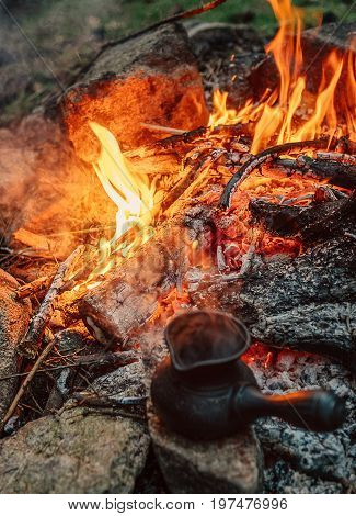 Making coffee process on campfire. Turkish cezva near open fire