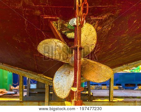 Old heavy ship's propeller (screw) of the rusty shipwreck vessel in the dry dock