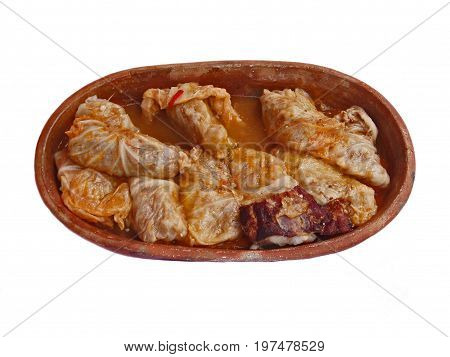 Cabbage rolls in a clay pot on a white background