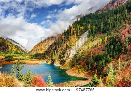 The Upper Seasonal Lake Among Colorful Fall Woods And Mountains